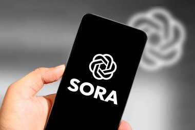 Akıllı telefon ekranında Sora Open Ai 'yi gösteren bir el ChatGPT, ai video yapımı sürümünü başlatır. Resimli yazı arkaplanı