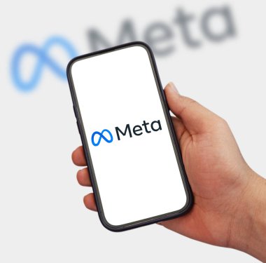 Akıllı telefonun beyaz ekranında Meta Şirketi logosu, resimli yazı arkaplanı