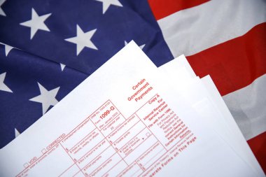 Bazı Hükümet Ödemeleri 1099 formu arka planda bir ABD bayrağına yerleştirildi.