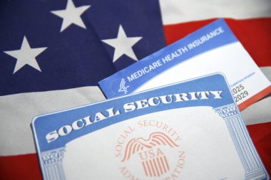 Sağlık sigortası olan ve arka planda sahte bilgi ve bayrak gösteren ABD sosyal güvenlik kartı. Amerikan vatandaşı ortak belge kavramı