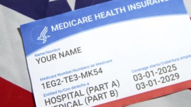 Arka planda Amerikan bayrağında gösterilen sağlık sigortası kartı örneği, 4K görüntü.