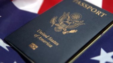Arka planında Amerikan bayrağı olan ABD pasaportu, ABD seyahat belgesinin 4k 'lik görüntüsü.