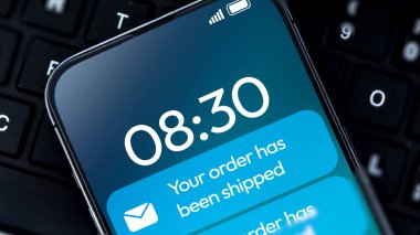 Arkaplanda klavye bulunan mavi renkli akıllı telefon ekranından sipariş edilmiş bildirim. E-ticaret siparişi nakliye arkaplanı