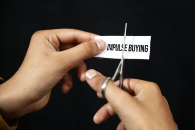 Impulse satın alma alışkanlığı konsepti makas ve siyah fon üzerinde eller kesme.