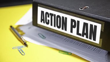 Yüzük klasörü ve dosyaların dışında yazılan Eylem Planı, 4K görüntüler yakın çekim. Planlama, strateji, iş büyümesi