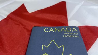Kanada pasaportu, arka planda bayrak ile yakın çekim, 4K görüntü. Seyahat, vatandaşlık ve milliyet kavramı