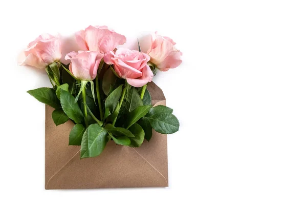 Stock image Pink roses in a paper envelope on a white background. Creative gift. Copy space. Photo