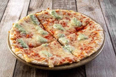 Tabağında mozzarella olan bir pizza. Pizza dört parçaya bölündü. Fast food. Fotoğraf.