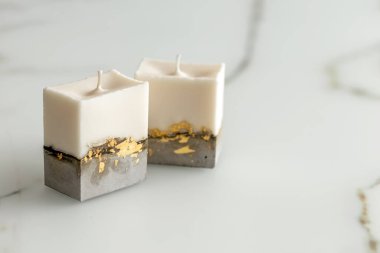 Beton bir zeminde dekoratif mumlar mermer bir masada bir odada. Modern iç mekan oturma odasında. Yakın plan. Fotoğraf.