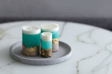 Beton bir zeminde dekoratif mumlar mermer bir masada bir odada. Modern iç mekan oturma odasında. Yakın plan. Fotoğraf.