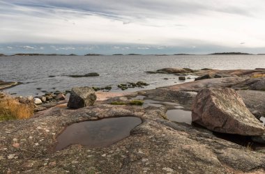 Kayalık deniz kıyısı ve adalar. Yumuşak kayalıklar denize iner. Fotoğraf.