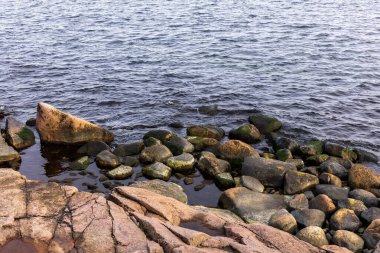 Kayalık deniz kıyısı ve adalar. Yumuşak kayalıklar denize iner. Fotoğraf.