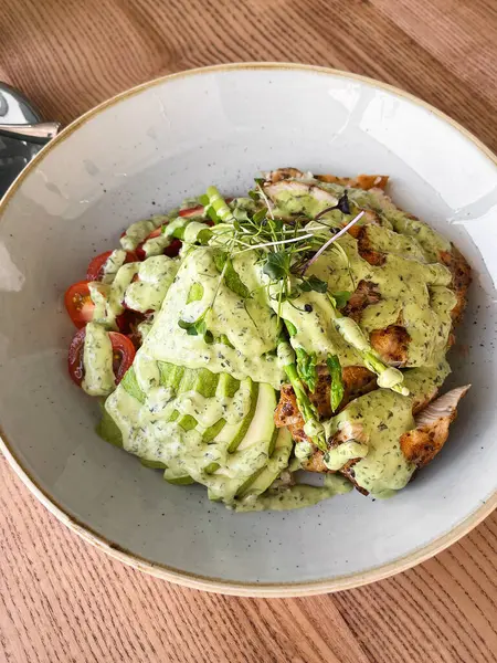 Seramik kasede yeşil sebze soslu ızgara tavuk avokado salatası. Sağlıklı Öğle Yemeği Konsepti