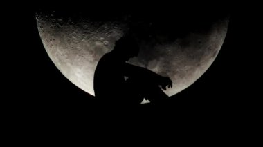 Arka planda ay ışığı olan yalnız bir adam. Umutsuz ve yalnızlık kavramı