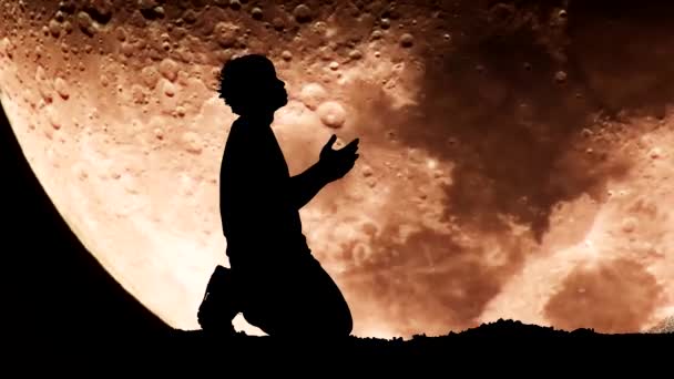 男が背景に大きな月に向かって祈っている 絶望的な孤独の概念 — ストック動画