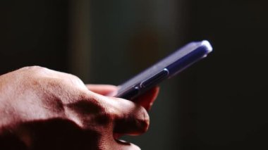 Cep telefonu kullanan bir adam. Adamın elleri cep telefonundan bilgi arıyor