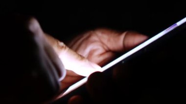Cep telefonu kullanan bir adam. Adamın elleri cep telefonundan bilgi arıyor