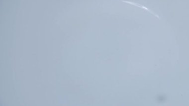 Slow motion 4X water droplets falling on water surface