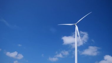 Mavi gökyüzüne karşı rüzgar türbinleri. Temiz enerji kavramı, alternatif enerji, rüzgar enerjisi ve çevresel koruma.