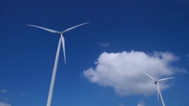 Mavi gökyüzüne karşı rüzgar türbinleri. Temiz enerji kavramı, alternatif enerji, rüzgar enerjisi ve çevresel koruma.