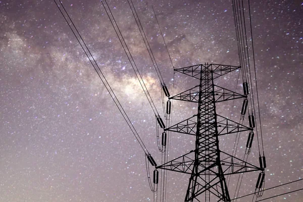 Electric power and nature conservation concept. High-voltage transmission towers and the beautiful Milky Way