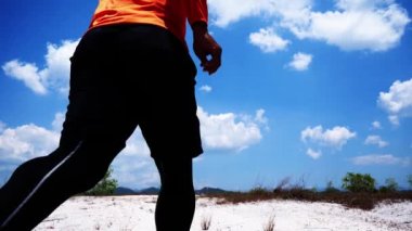 Spor giyimli bir adam dışarıda koşuyor.