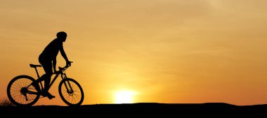 Akşamları çayırda egzersiz yapan bisikletçi silueti, sağlık hizmeti konsepti