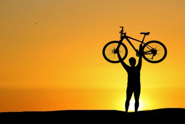 Akşamları çayırda egzersiz yapan bisikletçi silueti, sağlık hizmeti konsepti