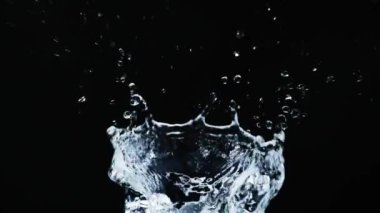 Siyah arkaplanda yavaş çekim 4X su sıçraması.