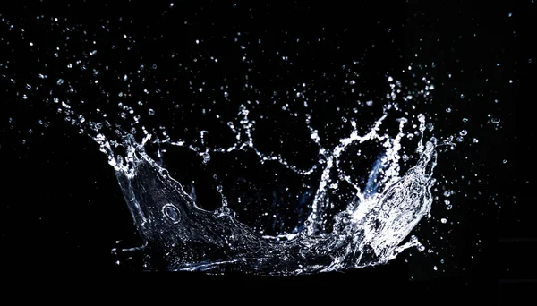 黒い背景に水をこぼす 水のスプラッシュさわやかな黒の背景 — ストック写真