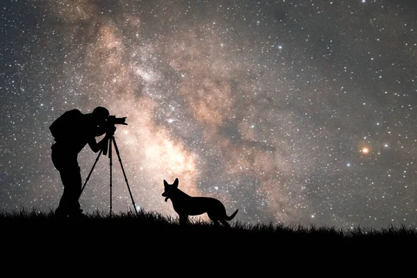 man making photo, silhouette of a dog with stars on a background