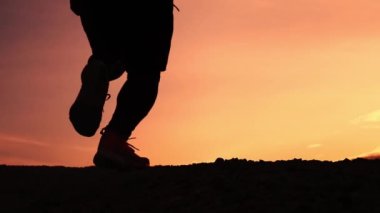 Ağır çekim. Adam akşamları koşu antrenmanı yapıyor. Koşan bir adamın silueti