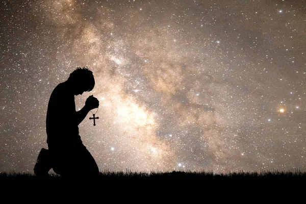 Betender Mann Mit Kreuz Auf Dem Hintergrund Der Sternenklaren Nacht Stockbild