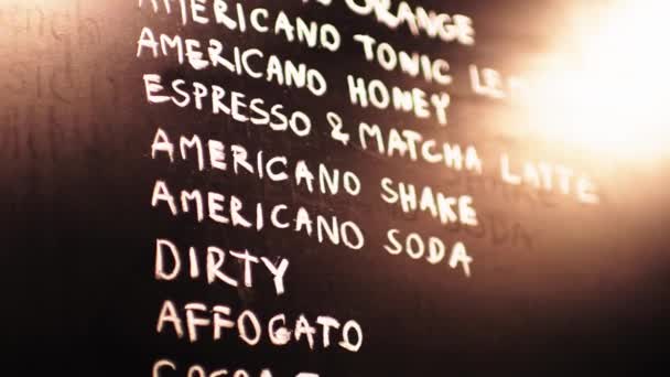 カフェの黒い背景にあるコーヒーのメニュー名をビデオ — ストック動画