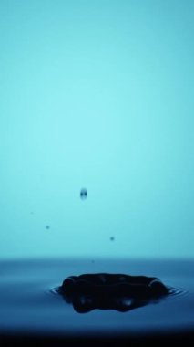 Su damlacıklarının atölye çekimi dalgalarla su yüzeyine düşüyor, yavaş çekim.