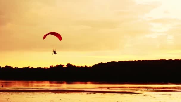 日落时滑翔机在海面上飞翔的轮廓 — 图库视频影像