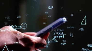 Animasyon veri setleri ve matematiksel formüllerin arka planında cep telefonu kullanan adam