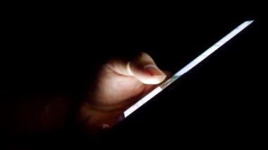 Cep telefonu kullanan bir adam. Adamın eli cep telefonundan bilgi arıyor