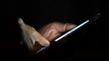 Cep telefonu kullanan bir adam. Adamın eli cep telefonundan bilgi arıyor
