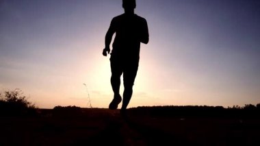 Geceleri mutlu bir şekilde koşan bir adamın silüeti. Egzersiz kavramı seni sağlıklı yapar..