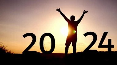Mutlu adamın silueti ellerini kaldırıyor ve 2023, 2024 işaretleri. Mutlu yıllar 2024 konsept video klibi.