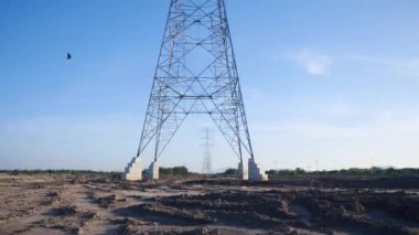 Teknoloji ve enerji güvenlik projelerinde kullanılan yüksek voltajlı elektrik direğinin kamera hareketi görüntüsü.