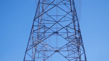 Teknoloji ve enerji güvenlik projelerinde kullanılan yüksek voltajlı elektrik direklerinin kamera hareketi görüntüsü.