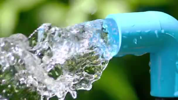 Clean Water Flowing Out Blue Pipe Green Blurred Background — Stock Video