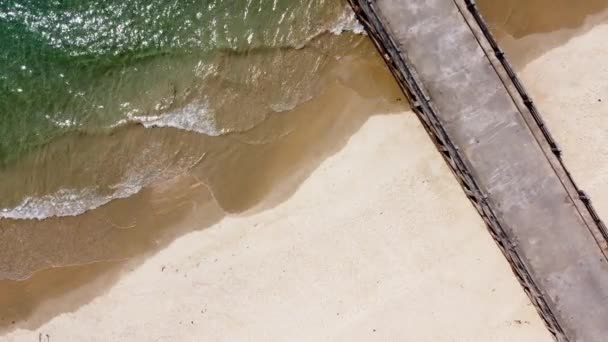 vue de dessus de belles vagues de mer sur la côte sablonneuse et la jetée