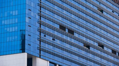 Mavi pencereli modern gökdelen binasının dışı.