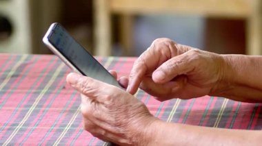 Ellerinde akıllı telefon kullanan yaşlıların yakın plan görüntüsü        