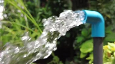 Bahçedeki mavi borudan akan temiz su