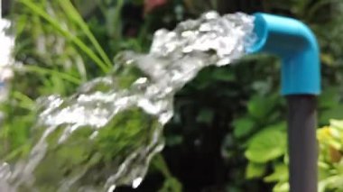 Bahçedeki mavi borudan akan temiz su