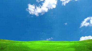 Mavi gökyüzü ve hareket eden bulutları olan çimen tarlası  